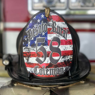 Firefighter helmet with American flag design and text, placed on a fire truck.