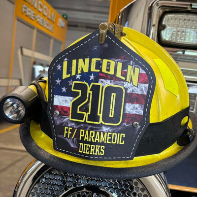 Firefighter helmet with 'Lincoln 210' and 'FF/Paramedic Diersk' on a fire truck background