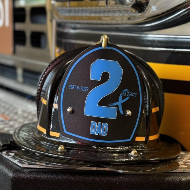 Fire truck with a helmet on top, featuring the number 2 and &