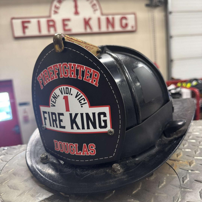 Firefighter helmet with 'Fire King' branding on a metallic surface.