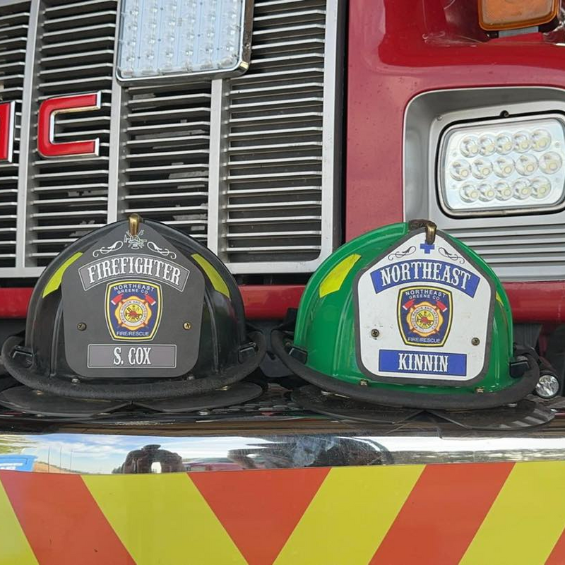 Two firefighter helmets in front of a GMC fire truck