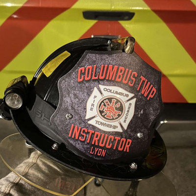 Fire helmet with 'Columbus Twp' and 'Instructor Lyon' text on a reflective background